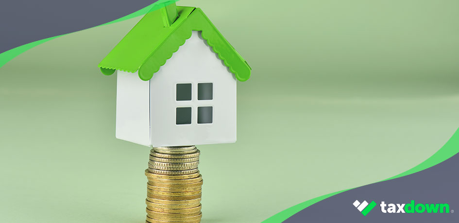 Vivienda sobre dinero representando el impuesto de bienes inmuebles